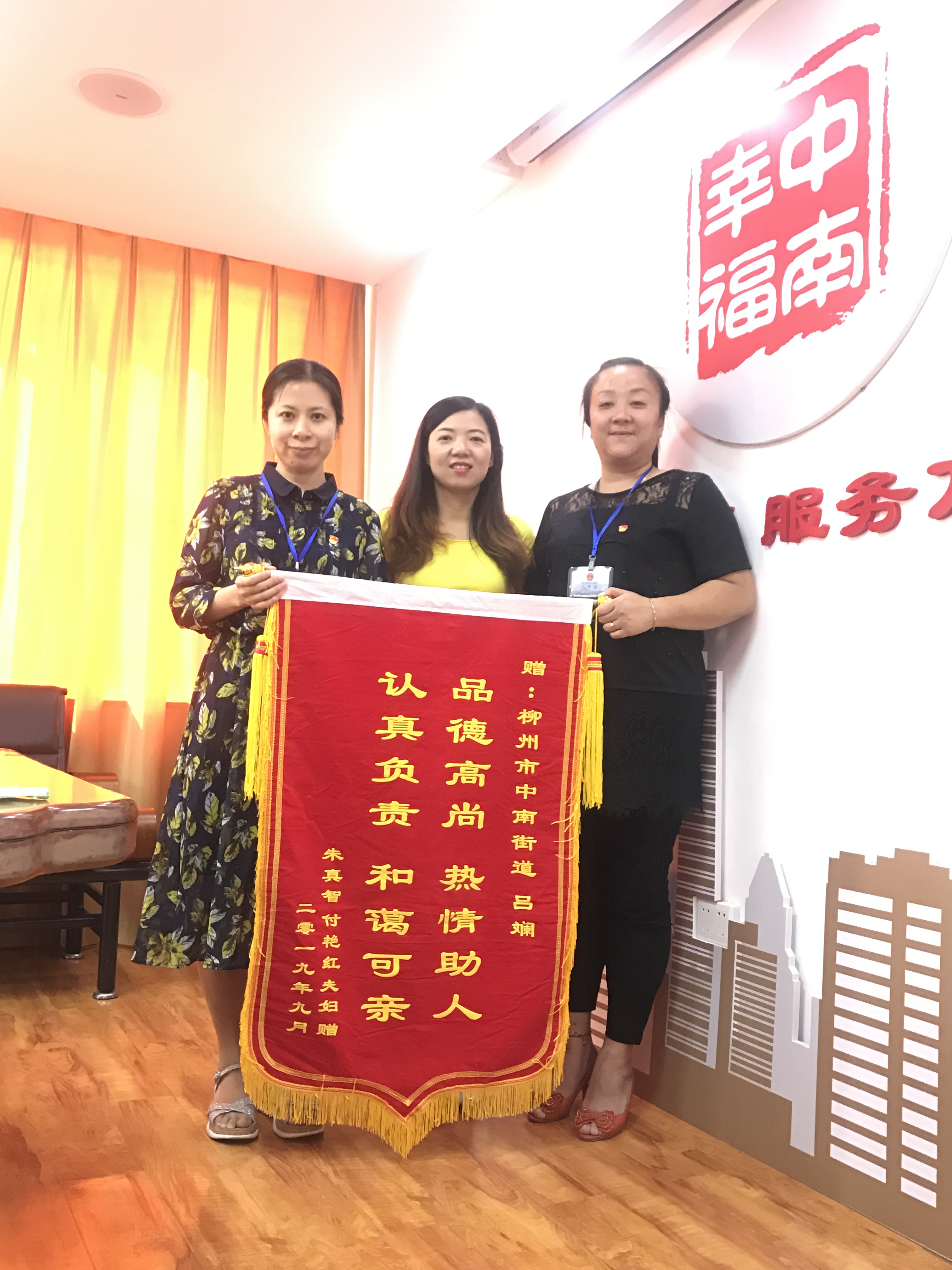 图为中南街道办副主任黄芳芳(左一)、工作人员吕斓(右一)与付女士(中间)合影