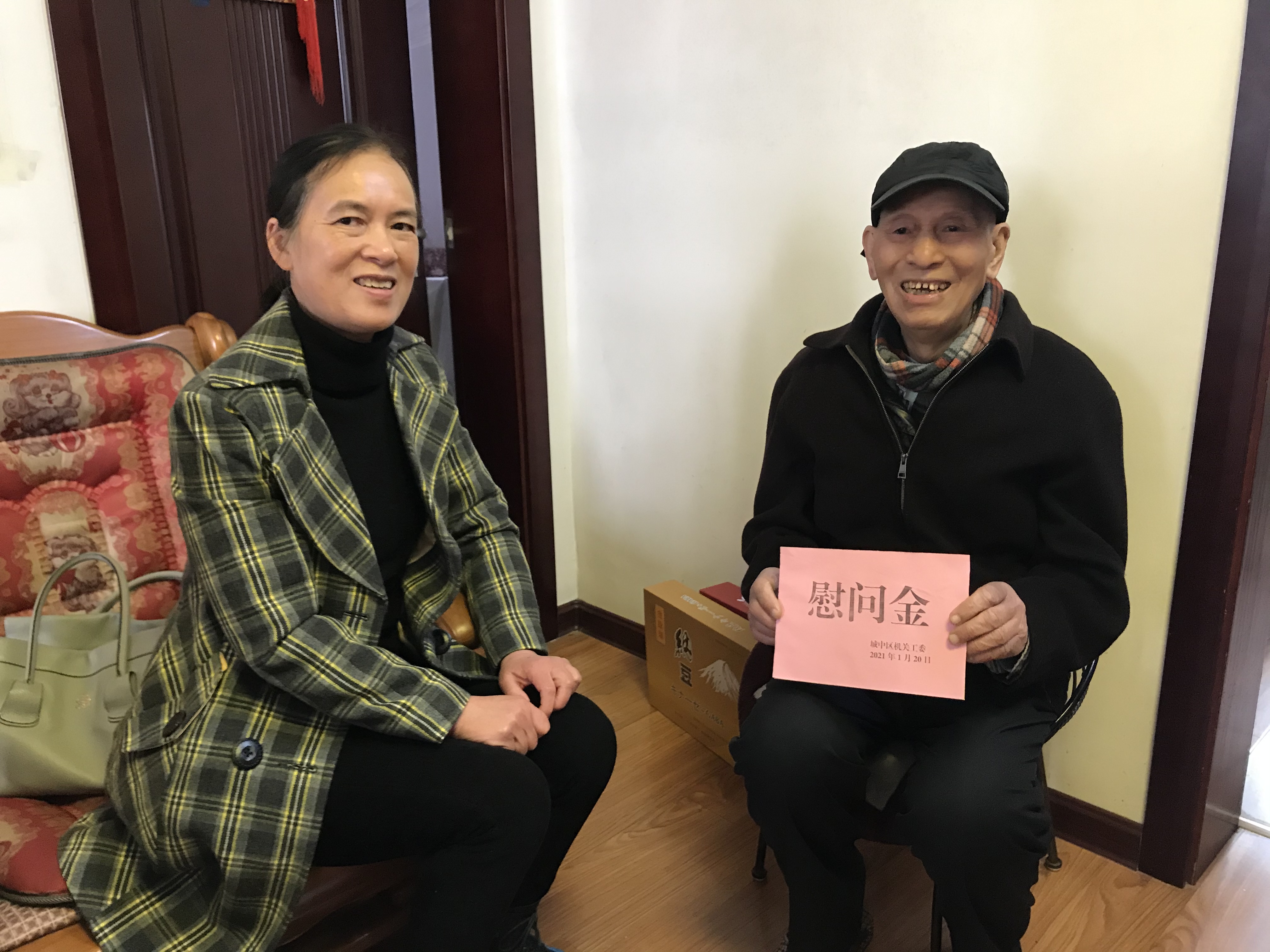 区直机关工委常务副书记范鹰(左一)向老党员蓝英辉送上慰问金.jpg