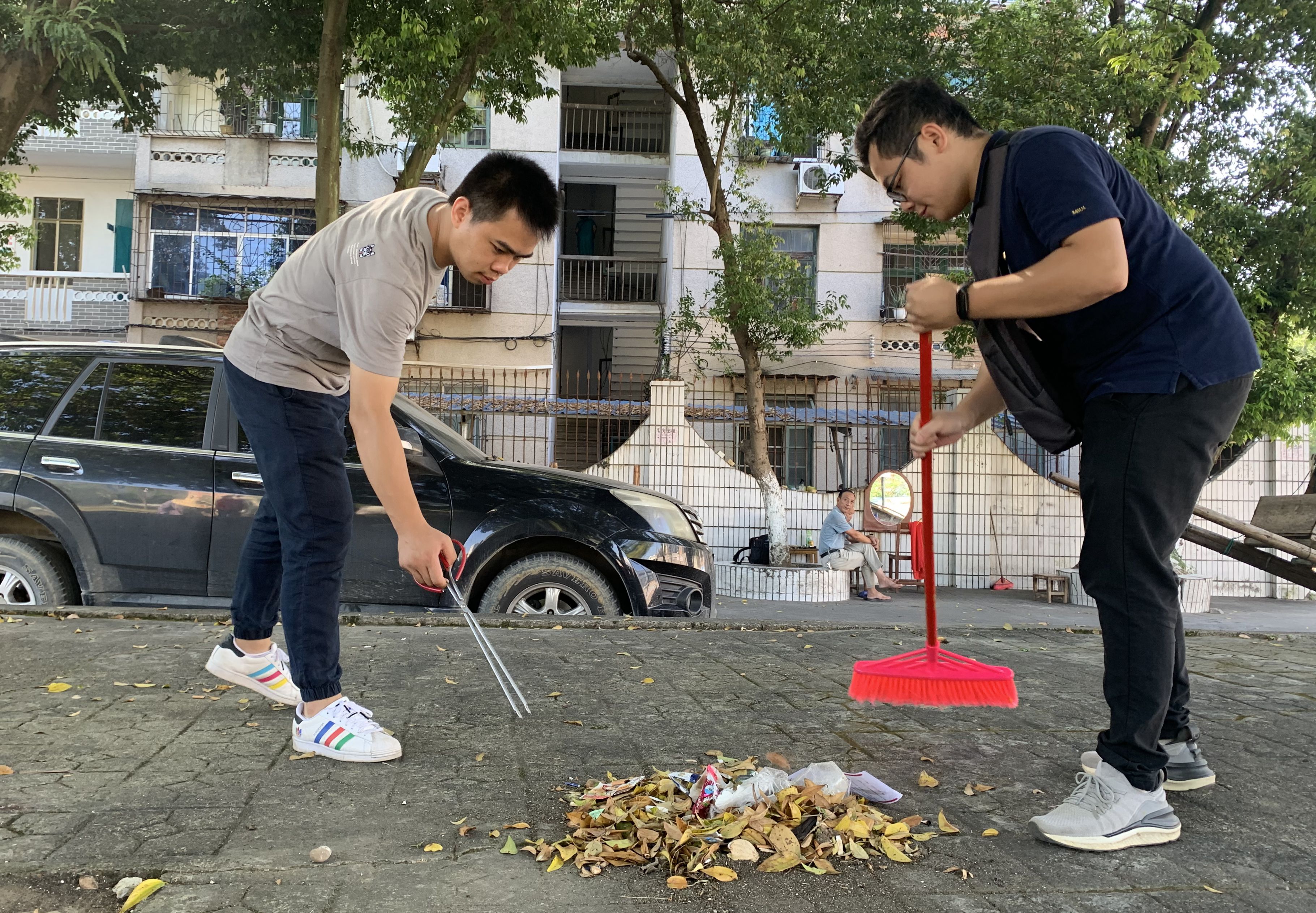 9月2日,在融安县长安镇河西小广场,两名党员干部在清扫路面堆积的落叶。.jpg