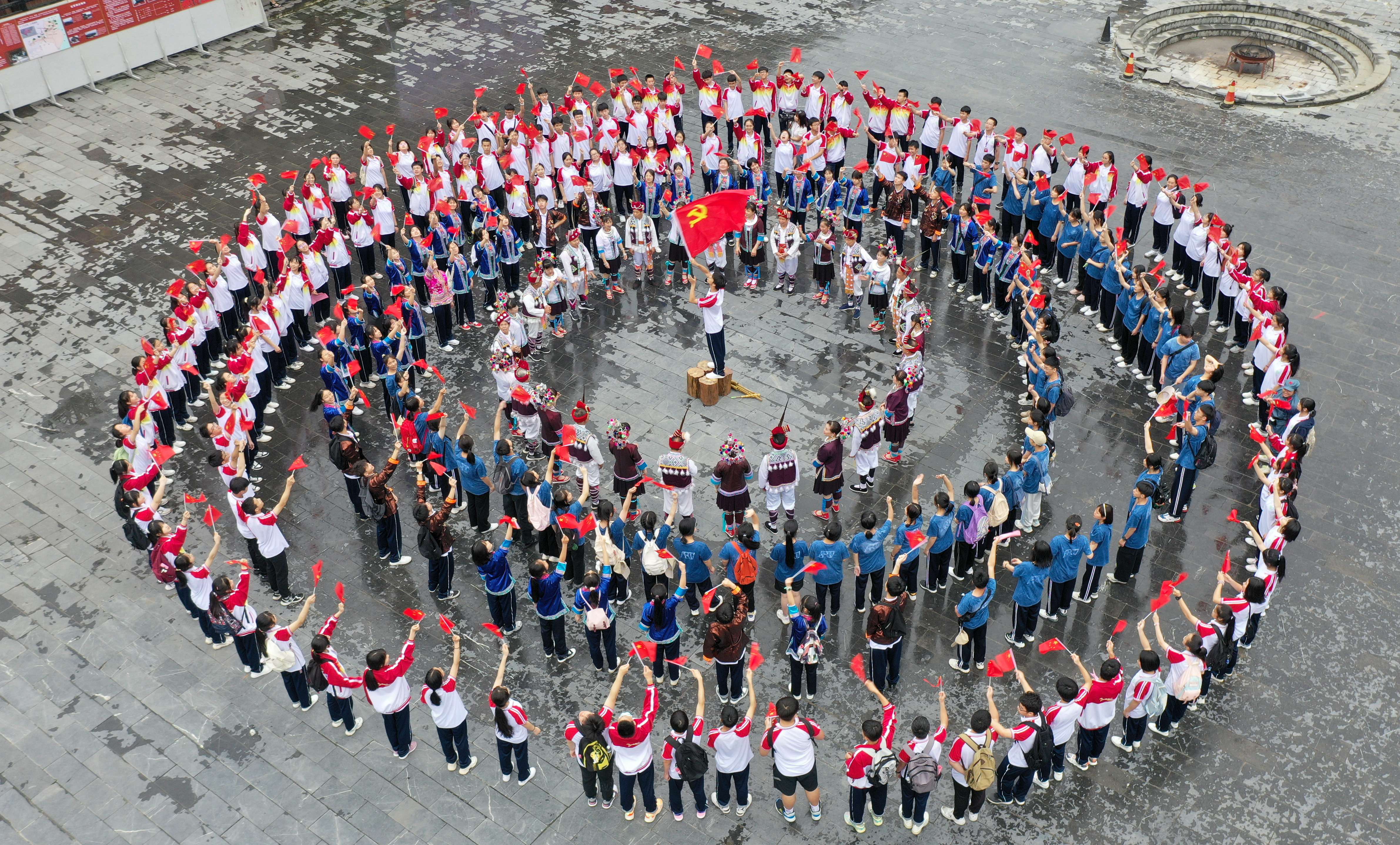 5月17日,在三江侗族自治县博物馆前,人们在合唱红色歌曲《没有共产党就没有新中国》。.jpg