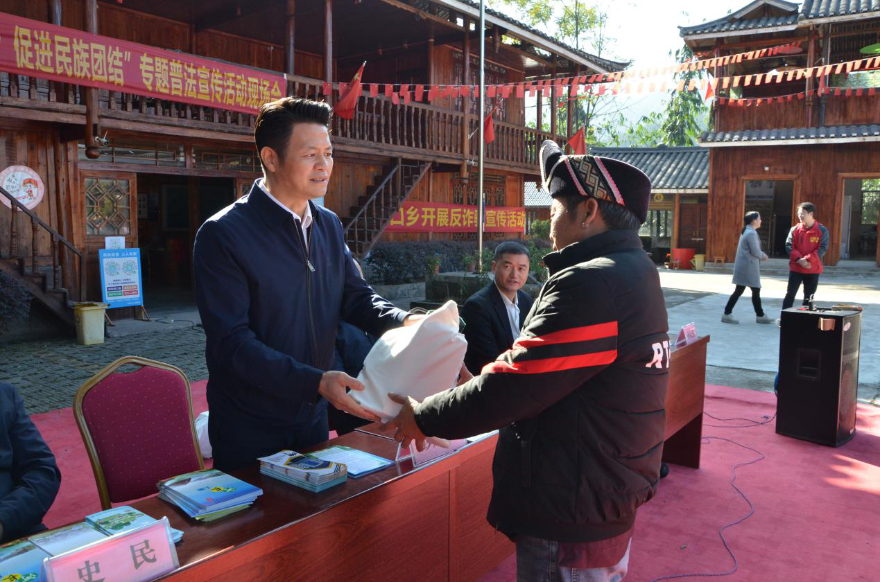 图为彭建国主任为群众发放有奖问答小礼品.png